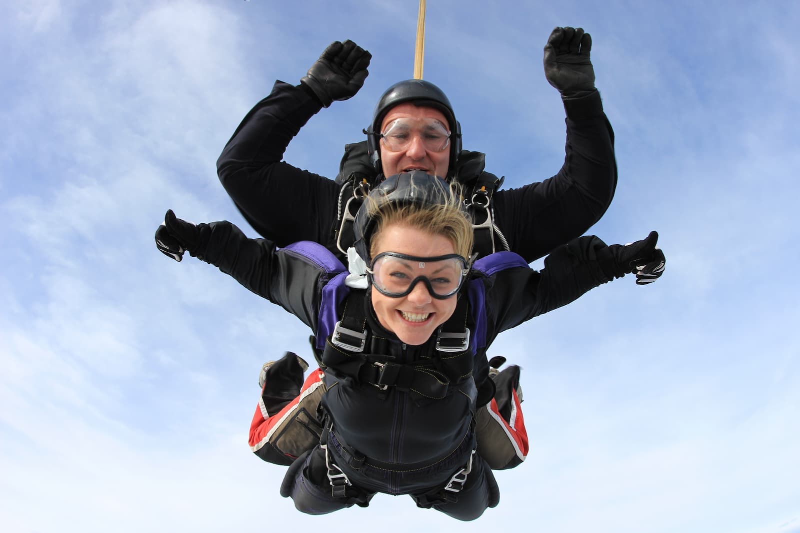 Two people skydiving against a blue sky