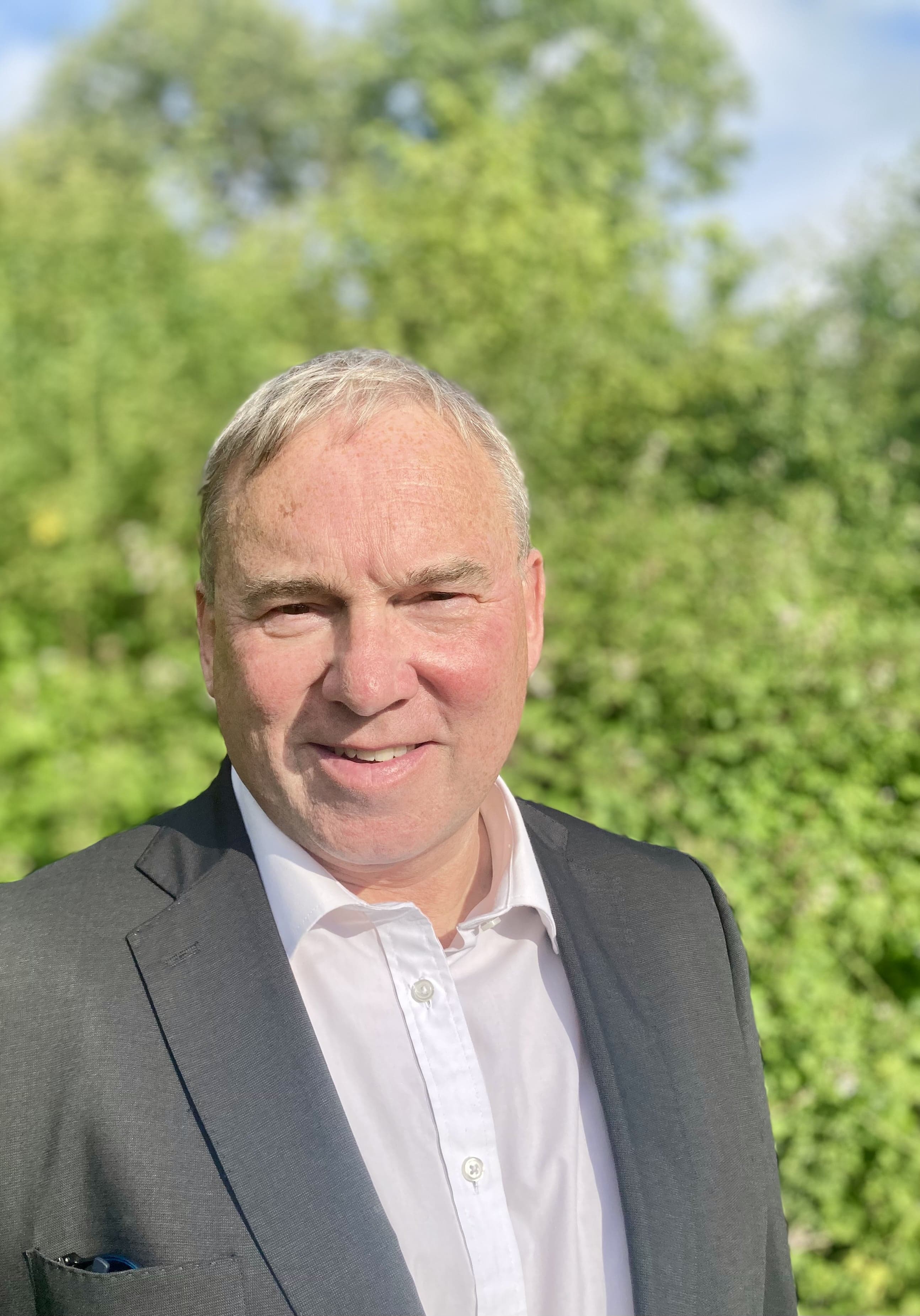 Head shot of Steve West against a backdrop of greenery