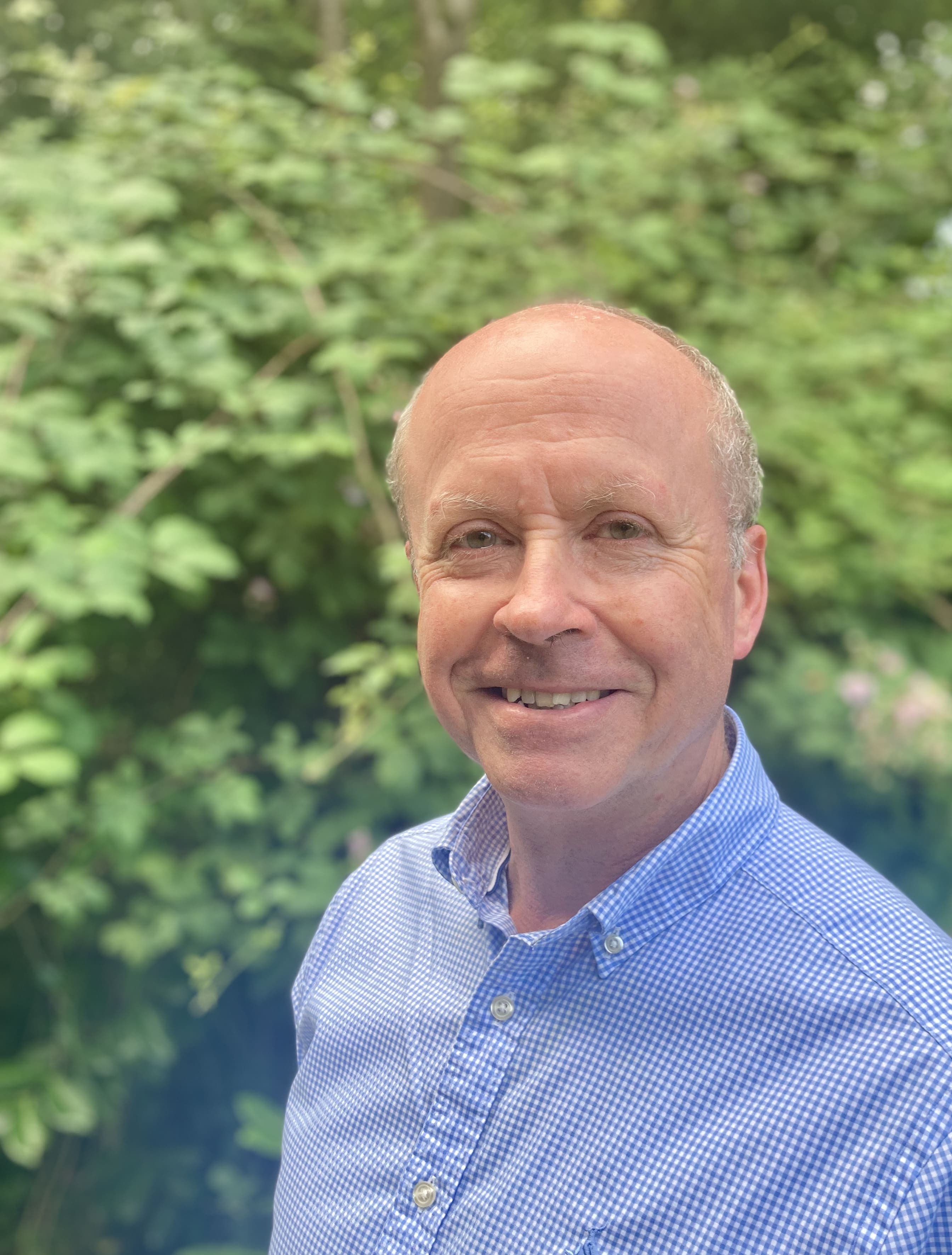 Head shot of Andrew Martyn-Johns against a backdrop of greenery