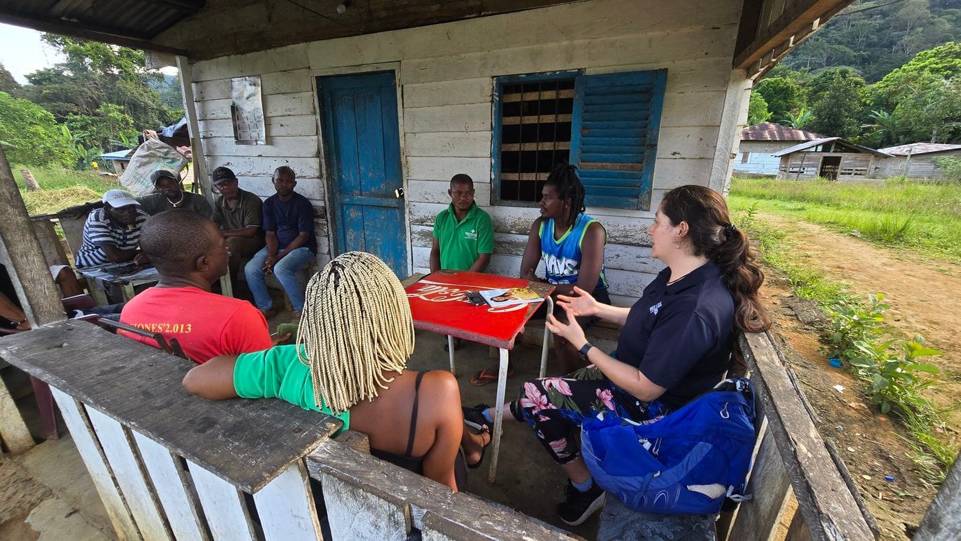 A group of people sitting on the porch of a wooden house
